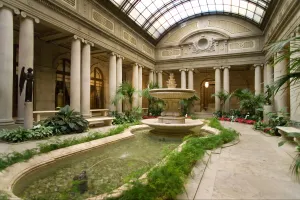 indoor garden showing fountain and pool surrounded by plants and flowers